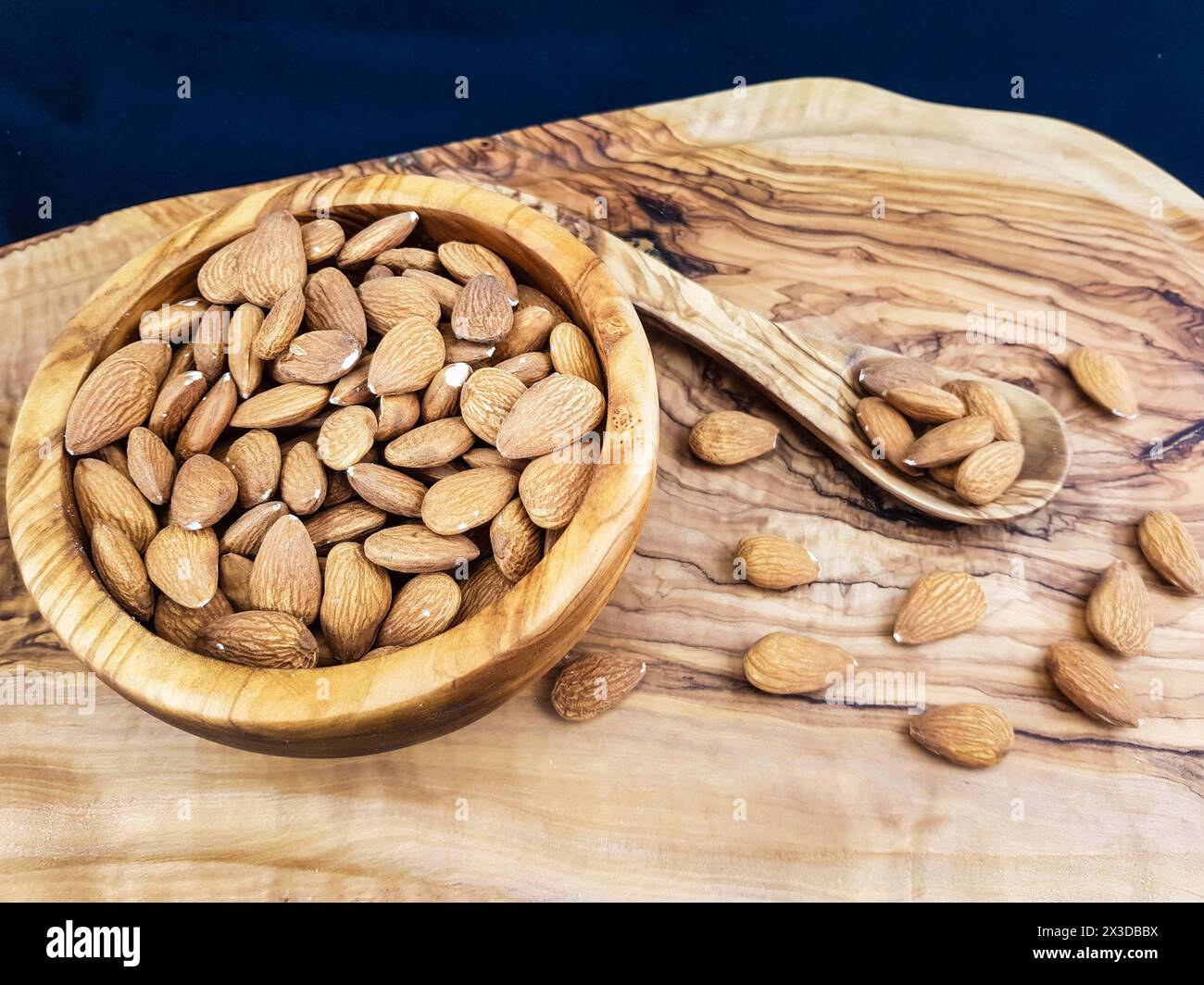 Mandel (Prunus dulcis, Prunus amygdalus, Amygdalus communis, Amygdalus dulcis), rohe Mandeln in einer Schüssel, mit einem Holzlöffel Stockfoto