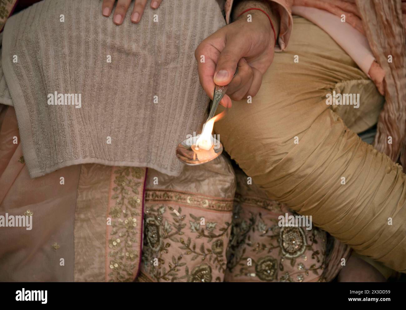 Traditionelle indische hinduistische Zeremonie, bei der die Feile in einem Löffel während der Verlobungsfeier übergeben wird Stockfoto