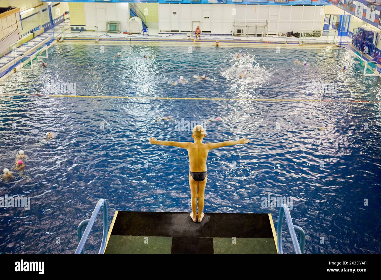 MOSKAU, RUSSLAND - 15. September 2017: Kleiner Junge steht auf einem Tauchturm im Universal Sport- und Unterhaltungskomplex Izmailovo. Pool mit Swimmingpool, Stockfoto