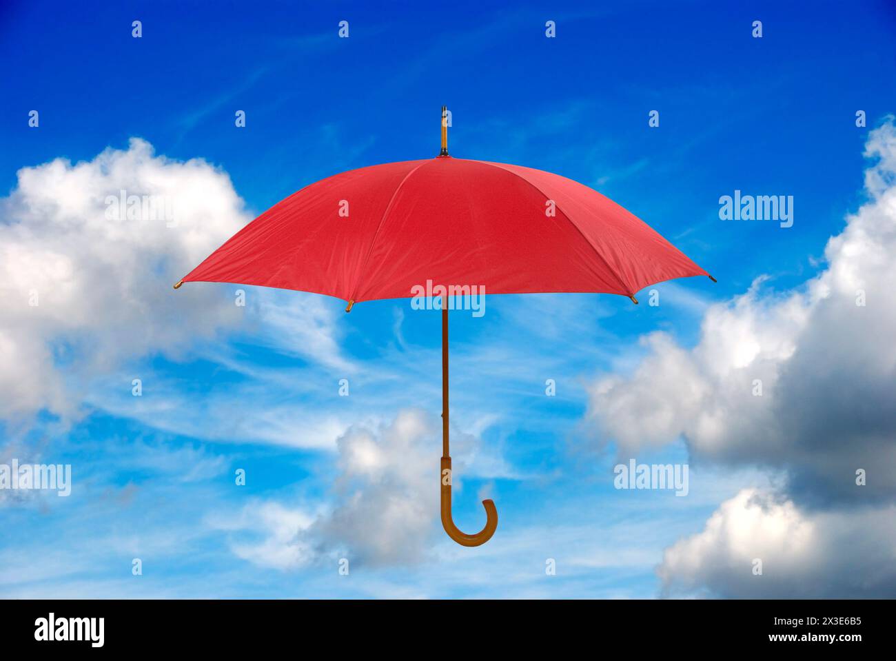 Roter Regenschirm über blauem Himmel Stockfoto