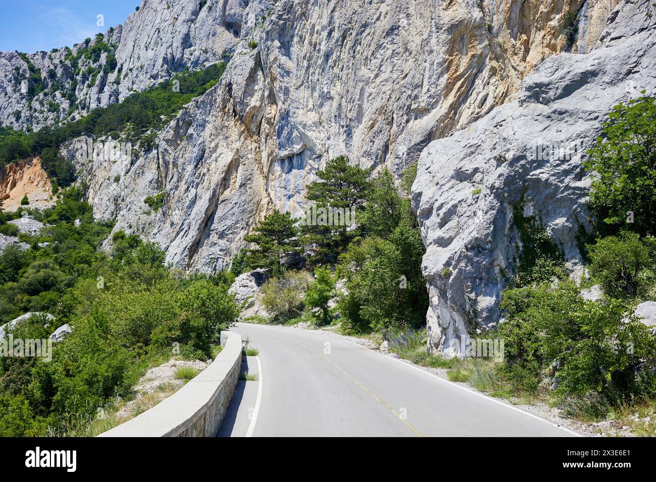 Asphaltstraße in den Bergen am sonnigen Tag. Stockfoto