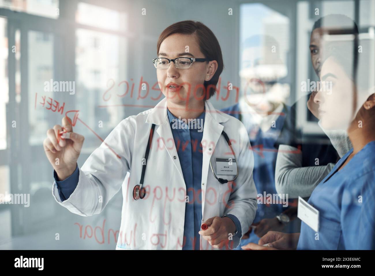 Arzt, Frau und Schreiben auf Glasplatte zur medizinischen Lösung, Lehre und Problemlösung an der Universität. Gesundheitsstudenten, Krankenschwester und Professor Stockfoto