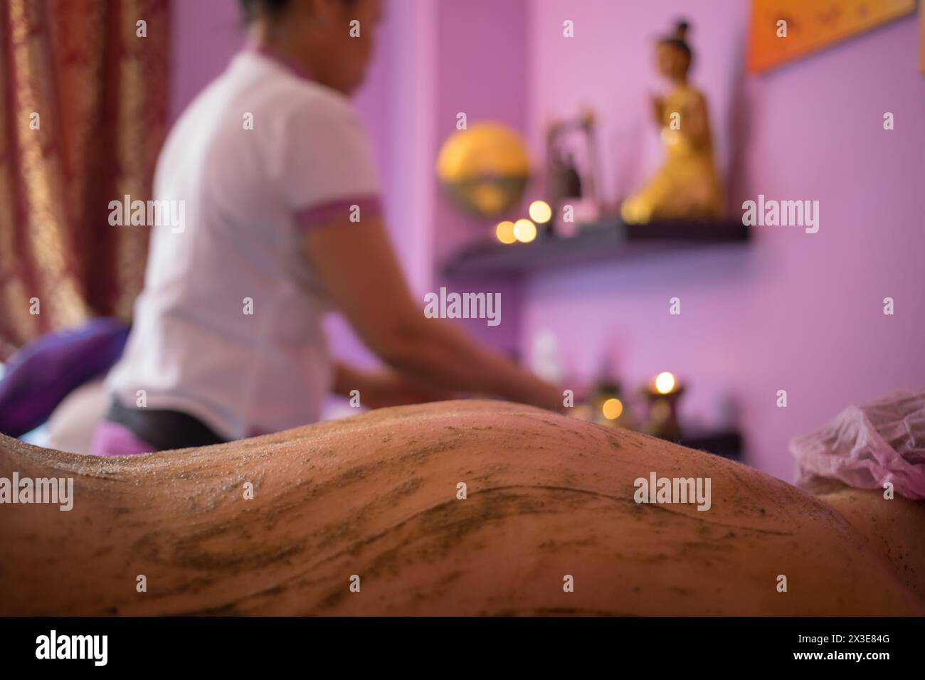 Weiblich zurück im Sand während der thai-Massage, Therapeutin im Spa-Raum außer Fokus Stockfoto