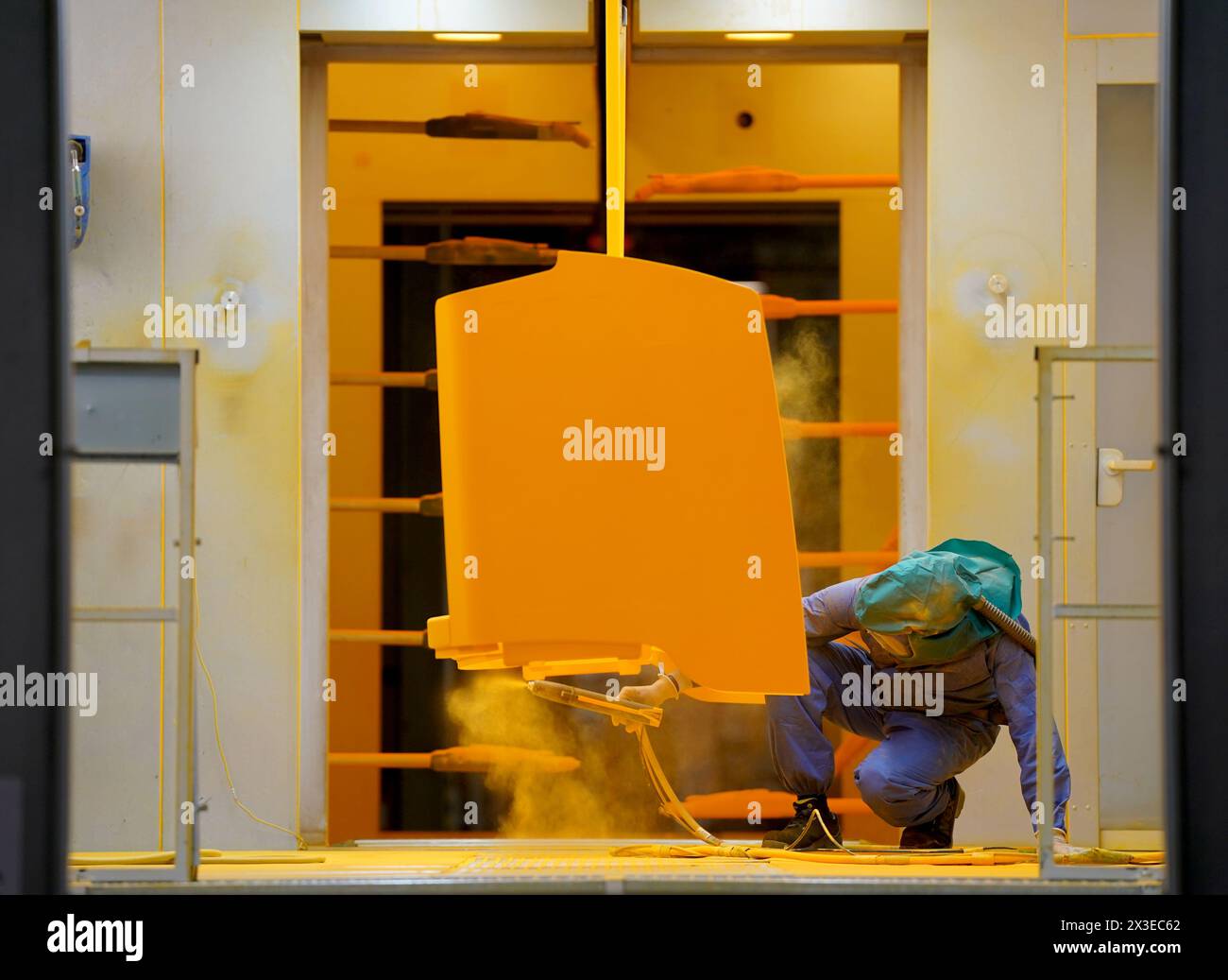 Norderstedt, Deutschland. April 2024. Bei der Jungheinrich AG arbeitet ein Mitarbeiter im Bereich Atemschutzkleidung in der Pulverbeschichtung in der Produktion von Flurförderzeugen. Die Bundesagentur für Arbeit gibt im April die Statistik für den deutschen Arbeitsmarkt bekannt. Quelle: Marcus Brandt/dpa/Alamy Live News Stockfoto