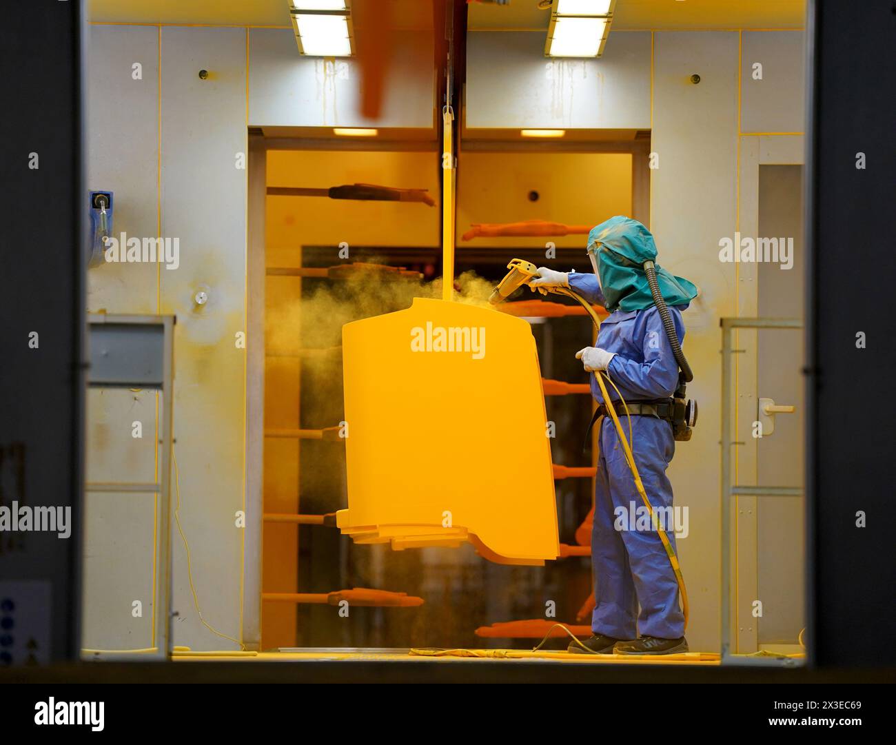 Norderstedt, Deutschland. April 2024. Bei der Jungheinrich AG arbeitet ein Mitarbeiter im Bereich Atemschutzkleidung in der Pulverbeschichtung in der Produktion von Flurförderzeugen. Die Bundesagentur für Arbeit gibt im April die Statistik für den deutschen Arbeitsmarkt bekannt. Quelle: Marcus Brandt/dpa/Alamy Live News Stockfoto