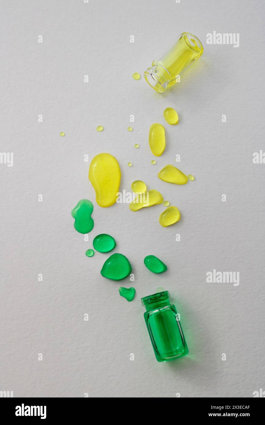 Flaschen mit verschütteter grüner und gelber Tinte Stockfoto