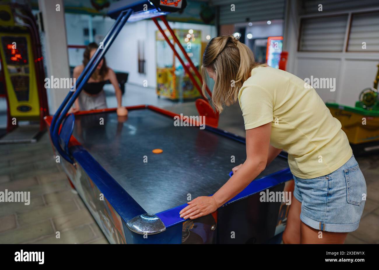 Familie spielt Air Hockey im Unterhaltungszentrum. Stockfoto