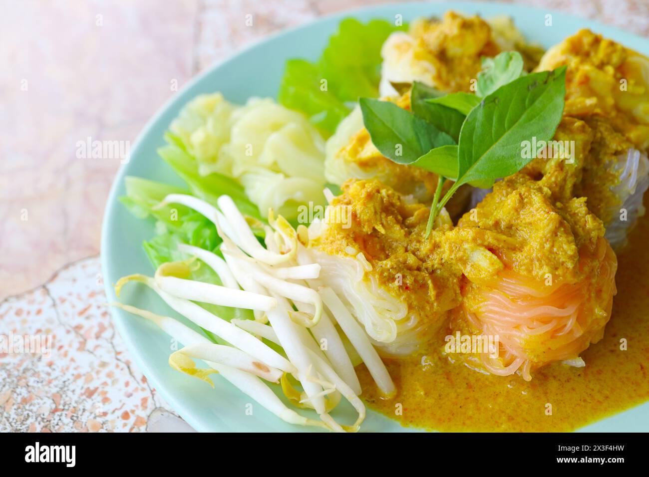 Köstliches thailändisches Gericht mit Khanom Chin Nam Ya Poo, einem Reis Vermicelli, serviert mit scharfem Krabbenfleisch, gelbem Curry und verschiedenen Gemüsesorten Stockfoto