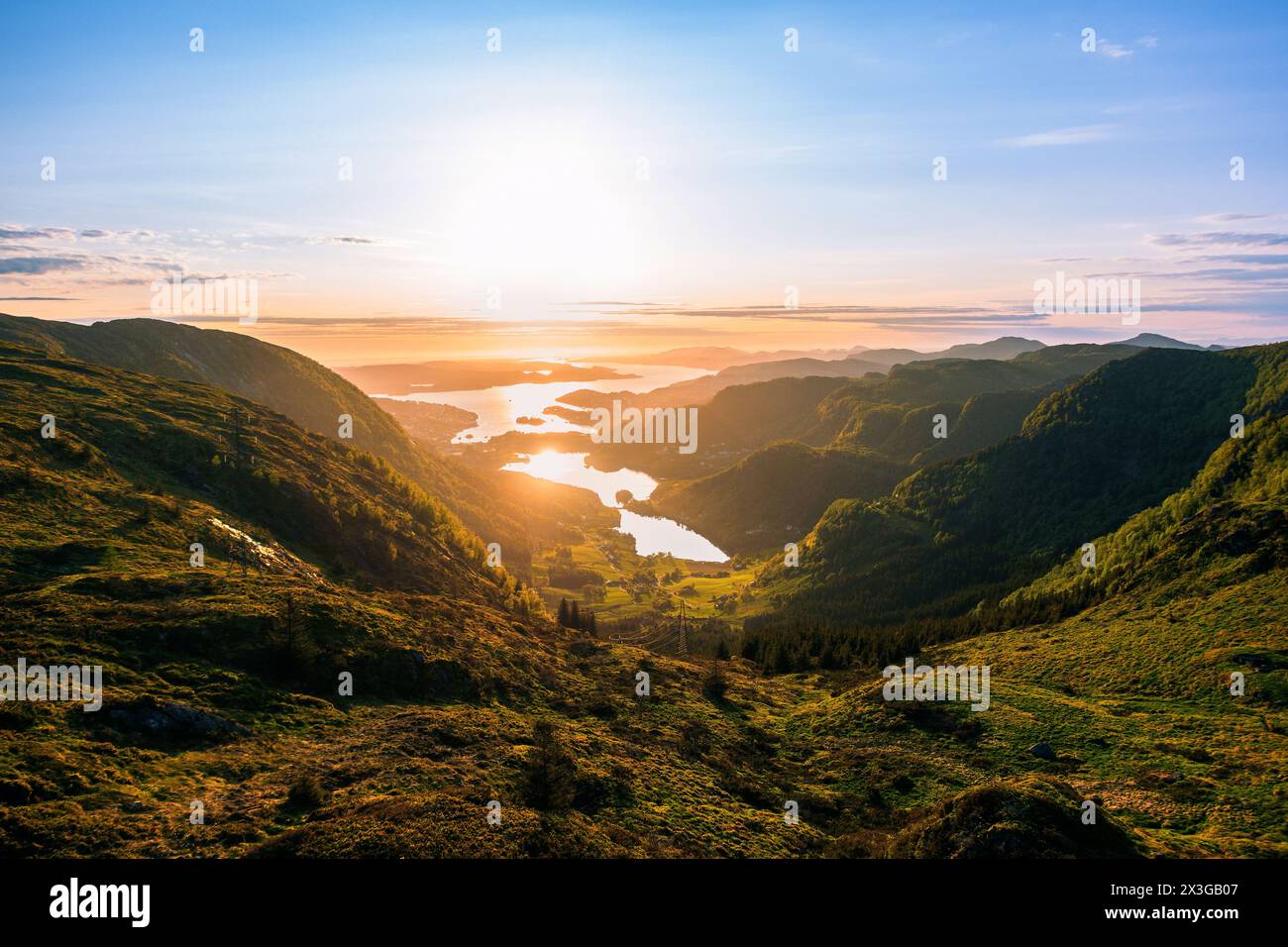 Grasbewachsener Talweg bei Sonnenuntergang mit alpenglow-Himmel vorbei an den Bergen in der Mitternachtssonne von Bergen, Norwegen Stockfoto