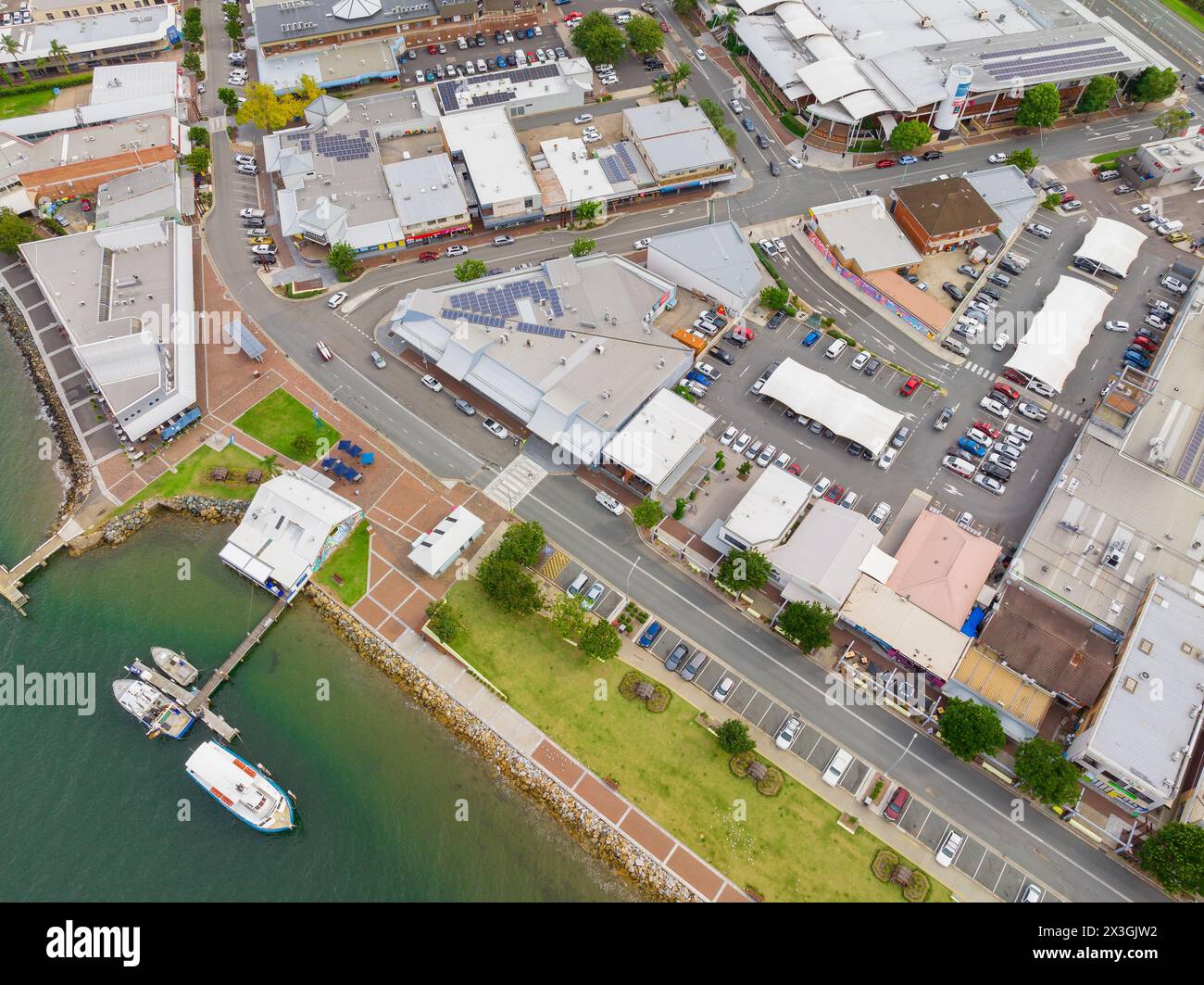 Aus der Vogelperspektive sehen Sie Boote, die an einem kleinen Steg entlang des Ufers und des Geschäftszentrums in Batemans Bay in New South Wales, Australien, anlegen. Stockfoto