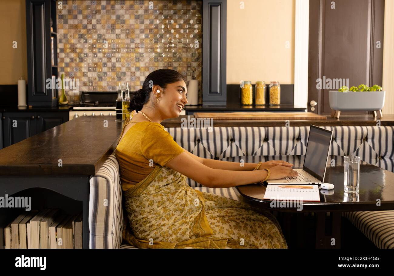 Indische Frau in traditioneller Kleidung, auf Videoanruf zu Hause Stockfoto