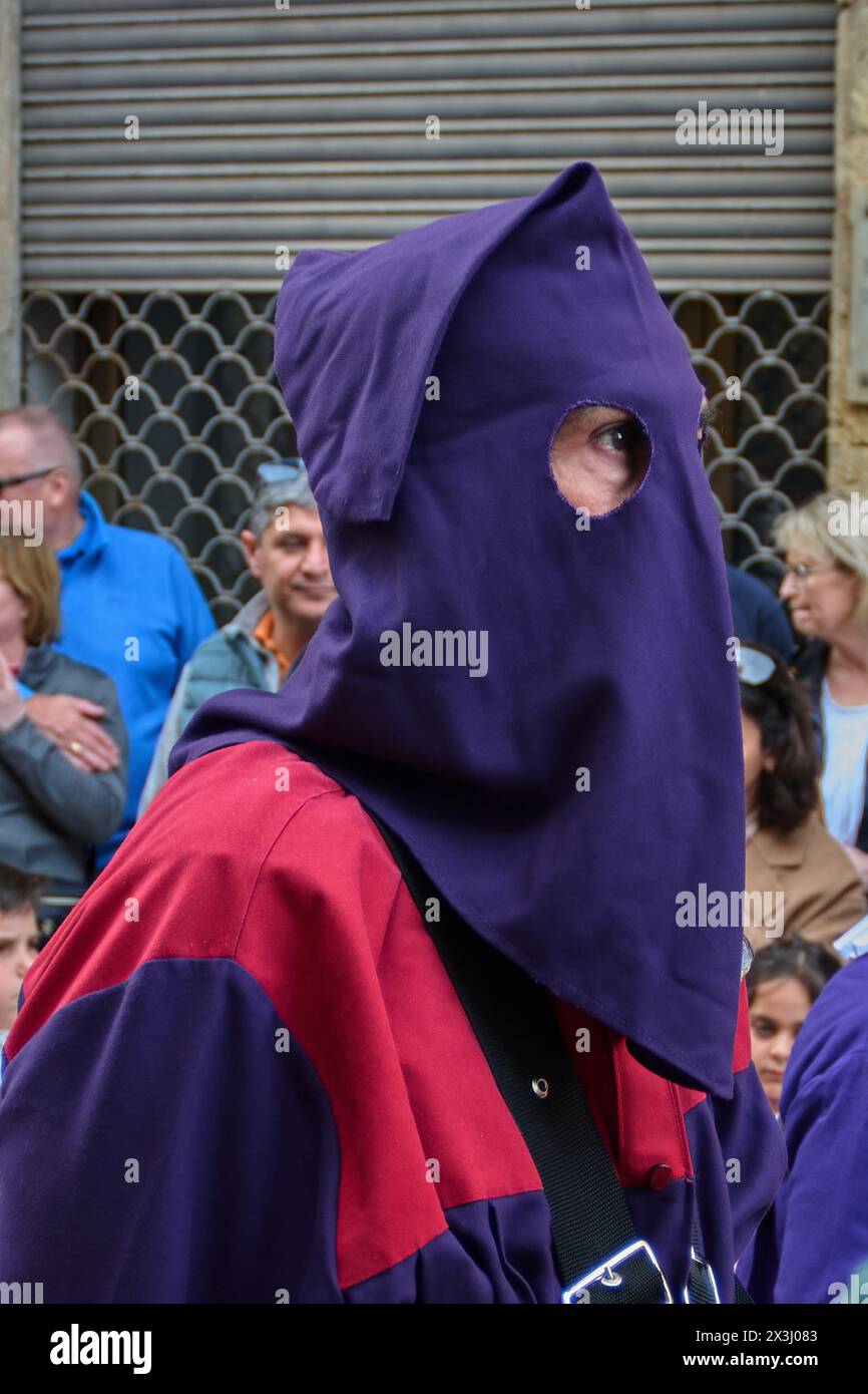 Tarragona, Spanien - 27. April 2024: Ein Teilnehmer in lila Kleidung sticht in der Menge in einer feierlichen Feier der Karwoche hervor. Stockfoto