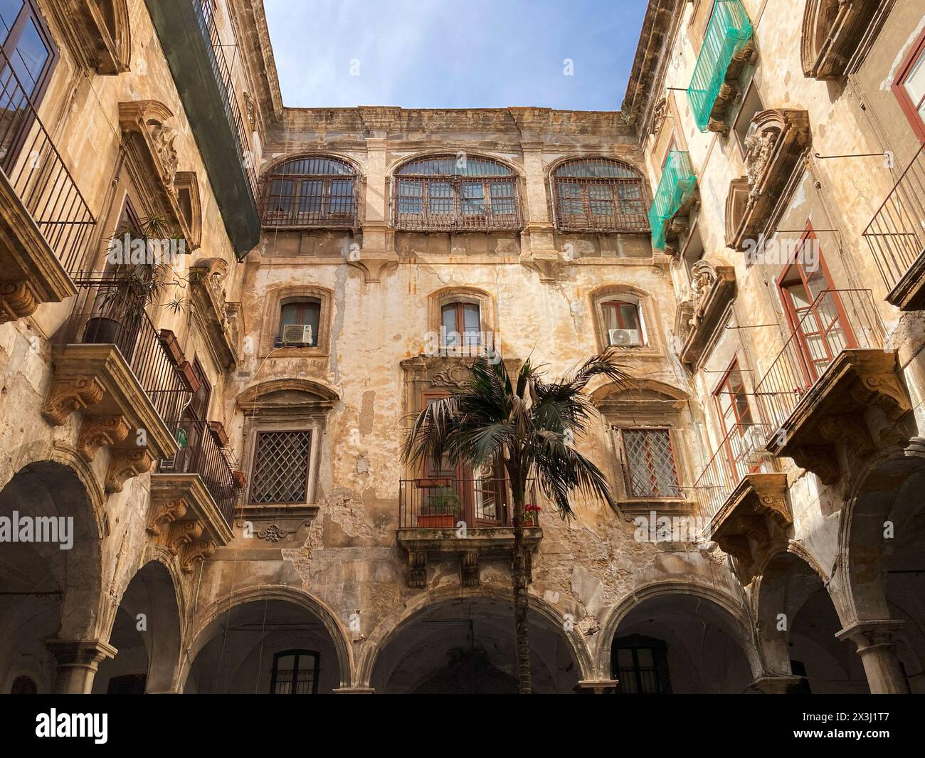 Italien, Palermo - 11. April 2024: Blick vom Innenhof auf das zerbröckelnde Ballaro Hotelgebäude Stockfoto