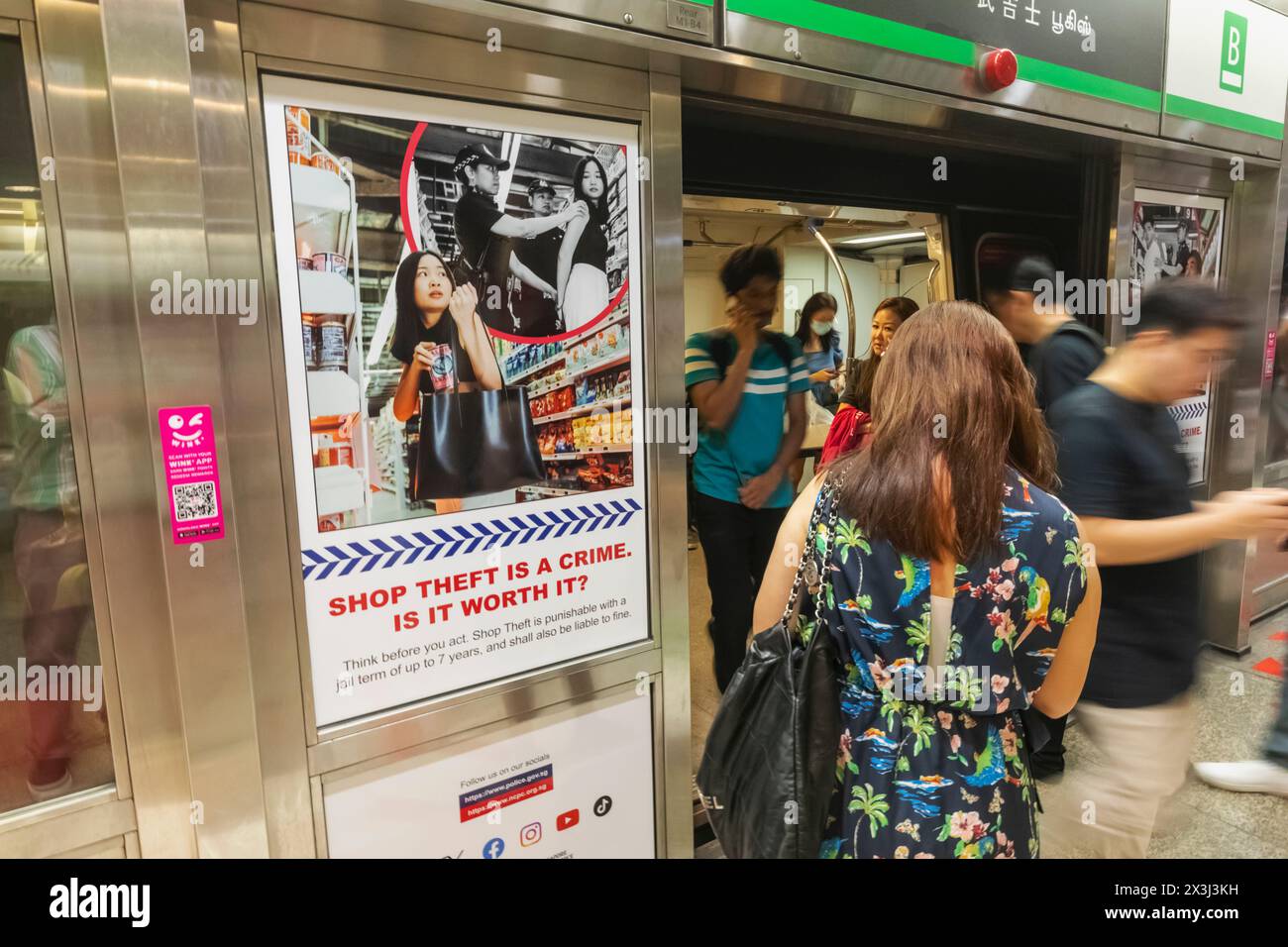 Asien, Singapur, MRT, Passagiere in U-Bahn-Beförderungen und Poster zur Sensibilisierung für Kriminalität Stockfoto