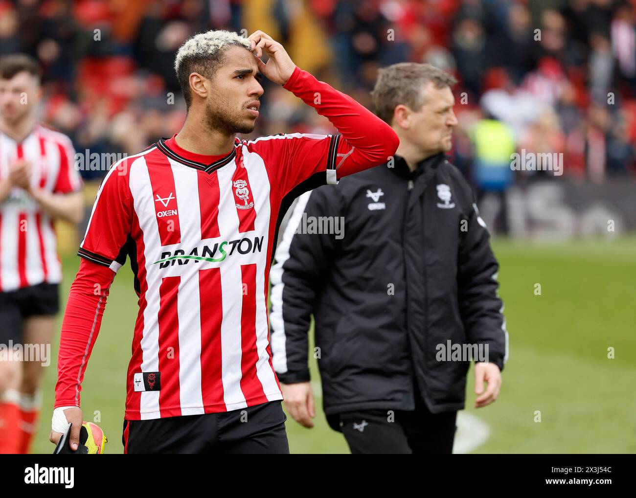 Lincoln City's Ethan Erhahon und Lincoln City Manager Michael Skubala nach dem Spiel der Sky Bet League One im LNER Stadium, Lincoln. Bilddatum: Samstag, 27. April 2024. Stockfoto