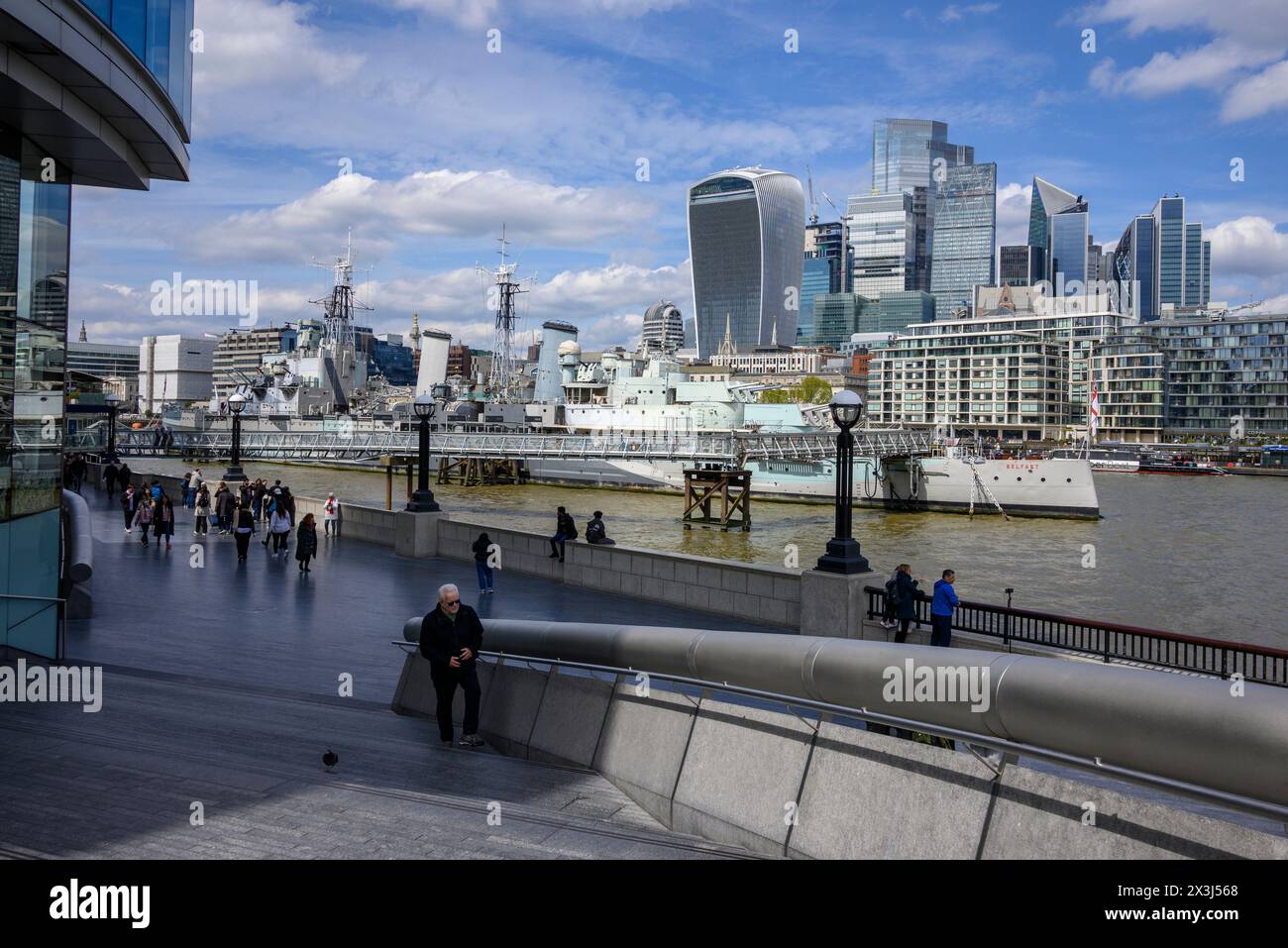 Die Menschen im April sonnen sich am More London Riverside, mit Blick auf die Skyline der City of London, South Bank, 2024 Stockfoto