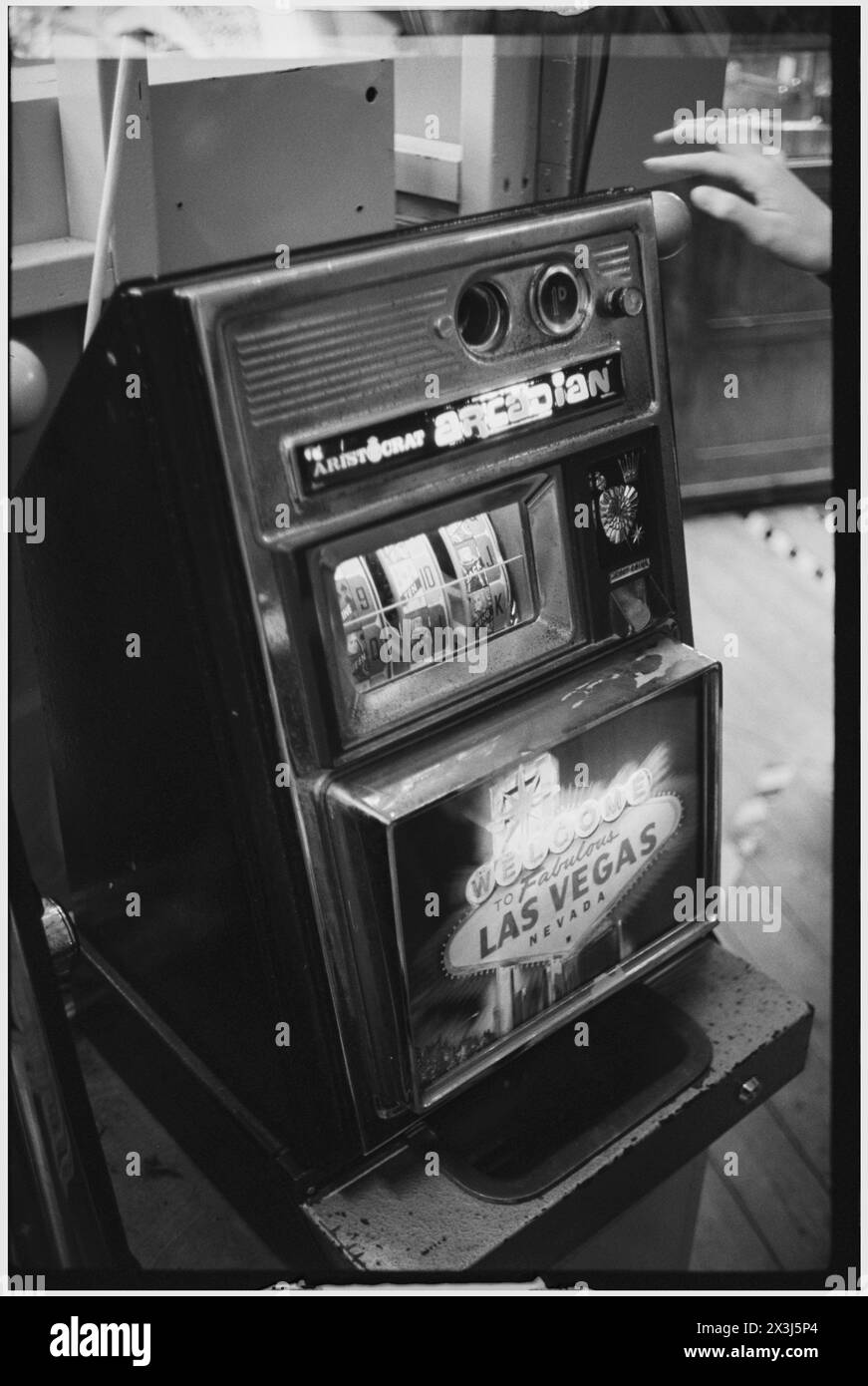 Ein klassischer einarmiger Banditenautomat mit Las Vegas auf der Vorderseite, kurz davor, gezogen und in einer Penny-Arkade in Schwarz-weiß gespielt zu werden Stockfoto