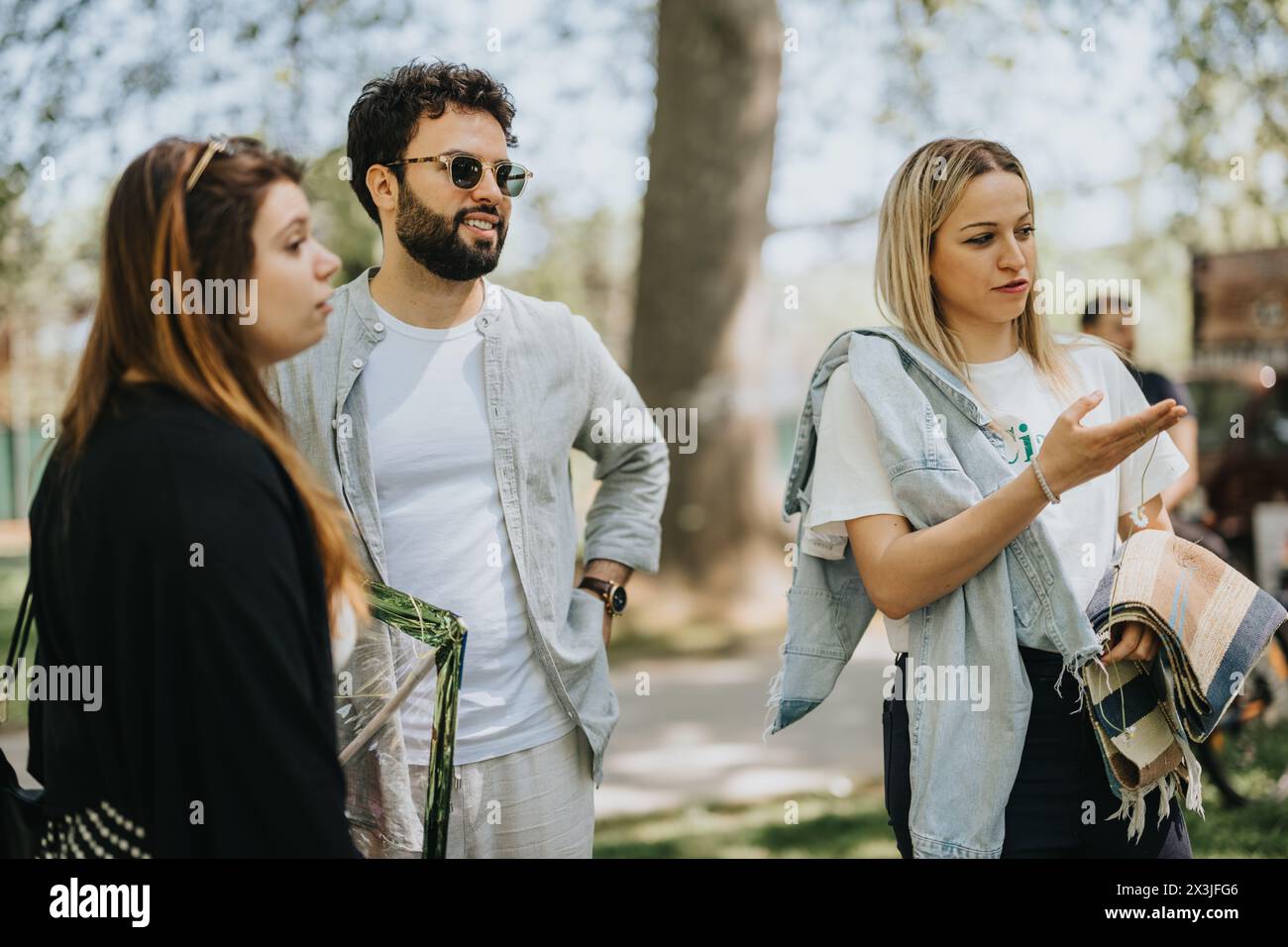 Multirassische Freunde, die sich in einem sonnigen Park unterhalten Stockfoto