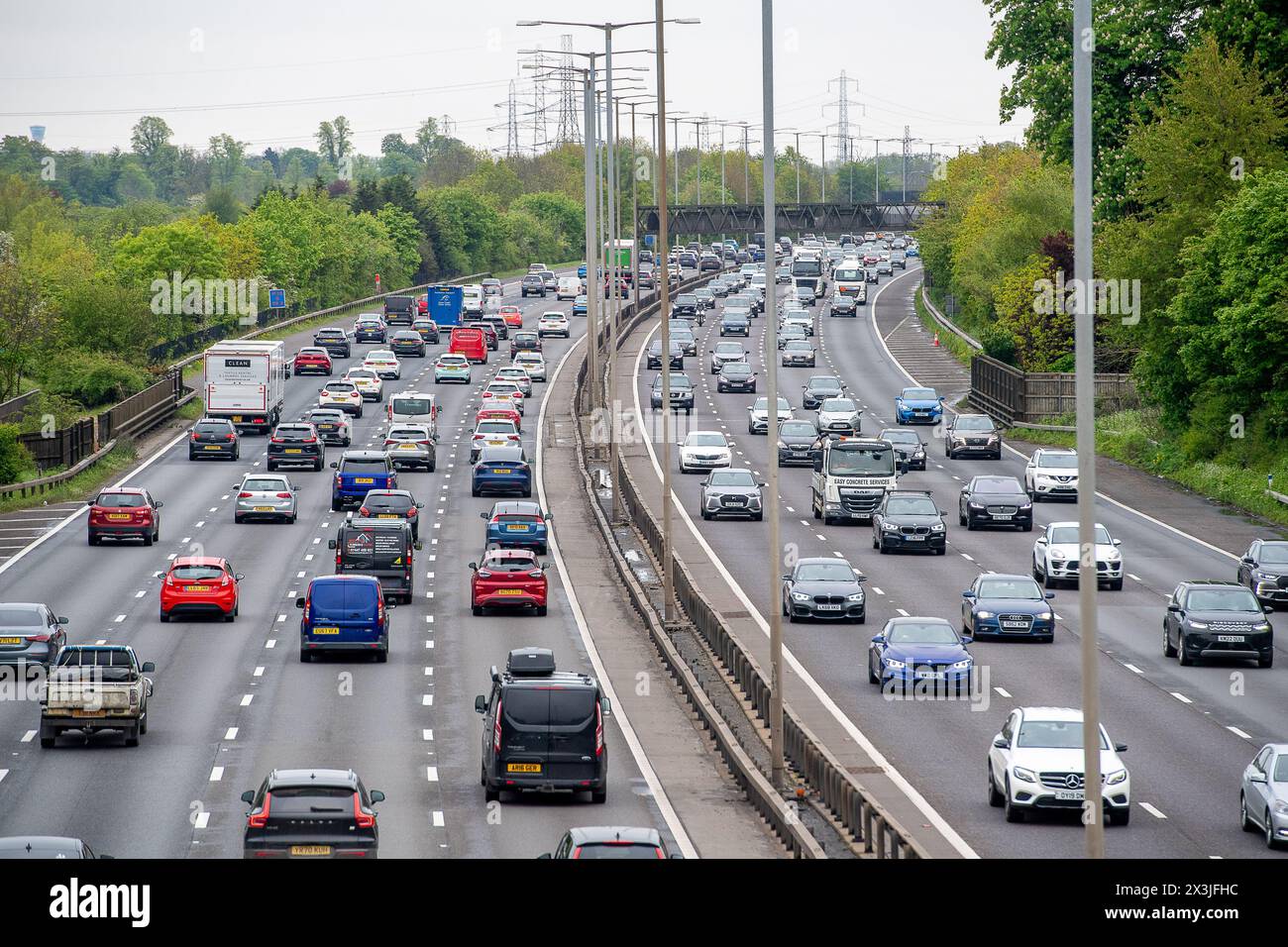 Iver Heath, Großbritannien. April 2024. Es war ein geschäftiger Tag auf der Autobahn M25, als der Verkehr heute durch Iver Heath in Buckinghamshire fuhr. Dieser Teil der M25 hat noch eine harte Schulter, aber andere Teile der M25 sind jetzt eine intelligente Autobahn, was bedeutet, dass die harte Schulter in eine aktive Fahrspur umgewandelt wurde und es stattdessen nur zeitweise Notunterkünfte gibt. Es wird gefordert, intelligente Autobahnen aus Sicherheitsgründen und wegen der Zahl der Todesfälle abzuschaffen. Vor einem Jahr kündigte Premierminister Rishi Sunak die Einführung weiterer Verbesserungen der intelligenten Autobahn bis zum an Stockfoto