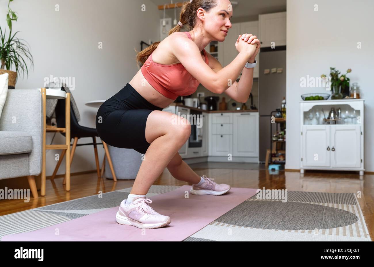 Bodybuilding zu Hause. Sportliche Frau, die zu Hause trainieren. Stockfoto