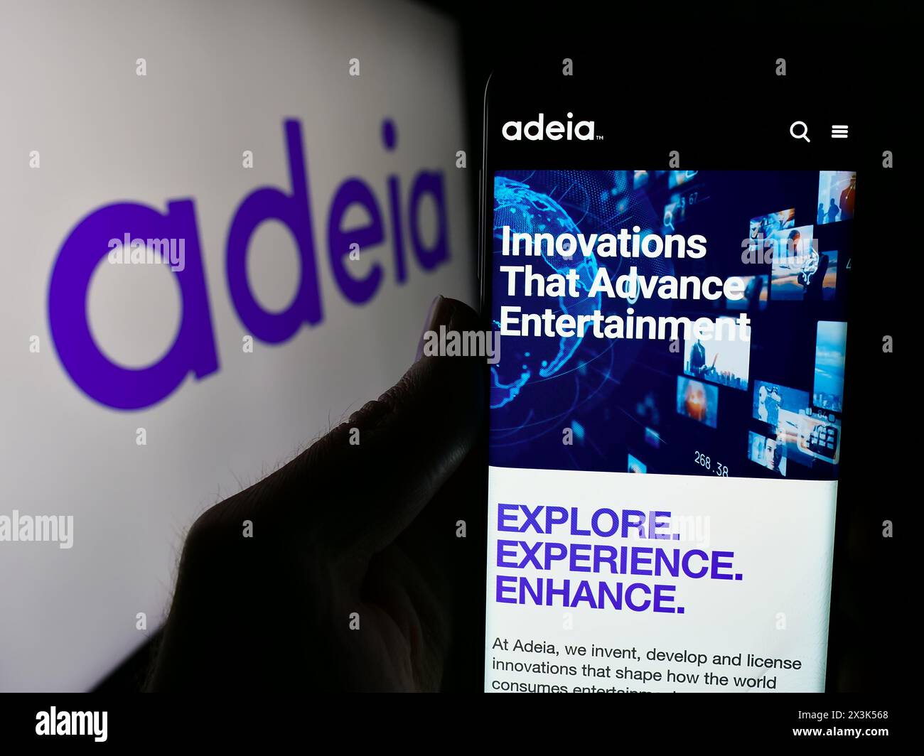 Person, die ein Mobiltelefon hält, mit der Webseite des US-amerikanischen Lizenzunternehmens Adeia Inc. Vor dem Logo. Konzentrieren Sie sich auf die Mitte des Telefondisplays. Stockfoto