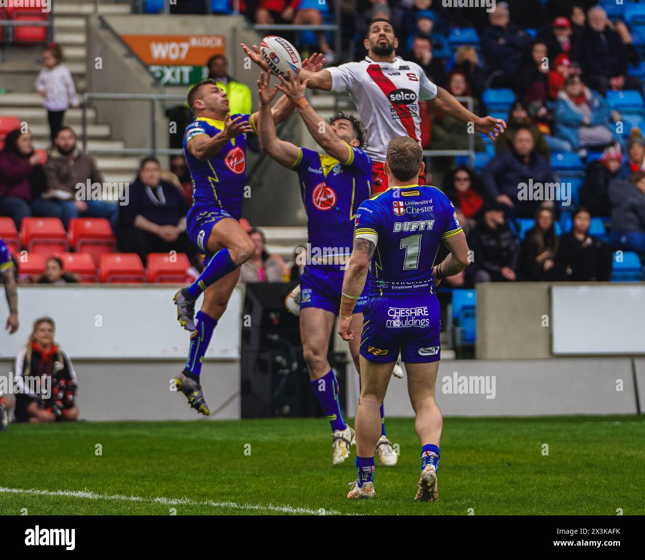 Salford, Manchester, Großbritannien. April 2024. Superliga Rugby: Salford Red Devils gegen Warrington Wolves im Salford Community Stadium. NENE MACDONALD sprang hoch, um den Ball zu erreichen, obwohl TOBY KING UND MATTY RUSSELL versucht hatten. James Giblin/Alamy Live News. Stockfoto