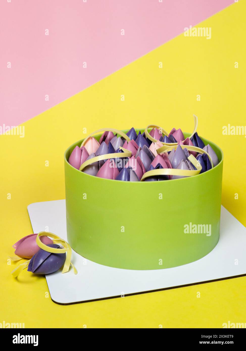 Nahaufnahme von Moussekuchen mit Schokoladentulpe, Nahaufnahme, gelber und rosa Hintergrund. Back- und Süßwarenkonzept. Französisches Dessert Stockfoto