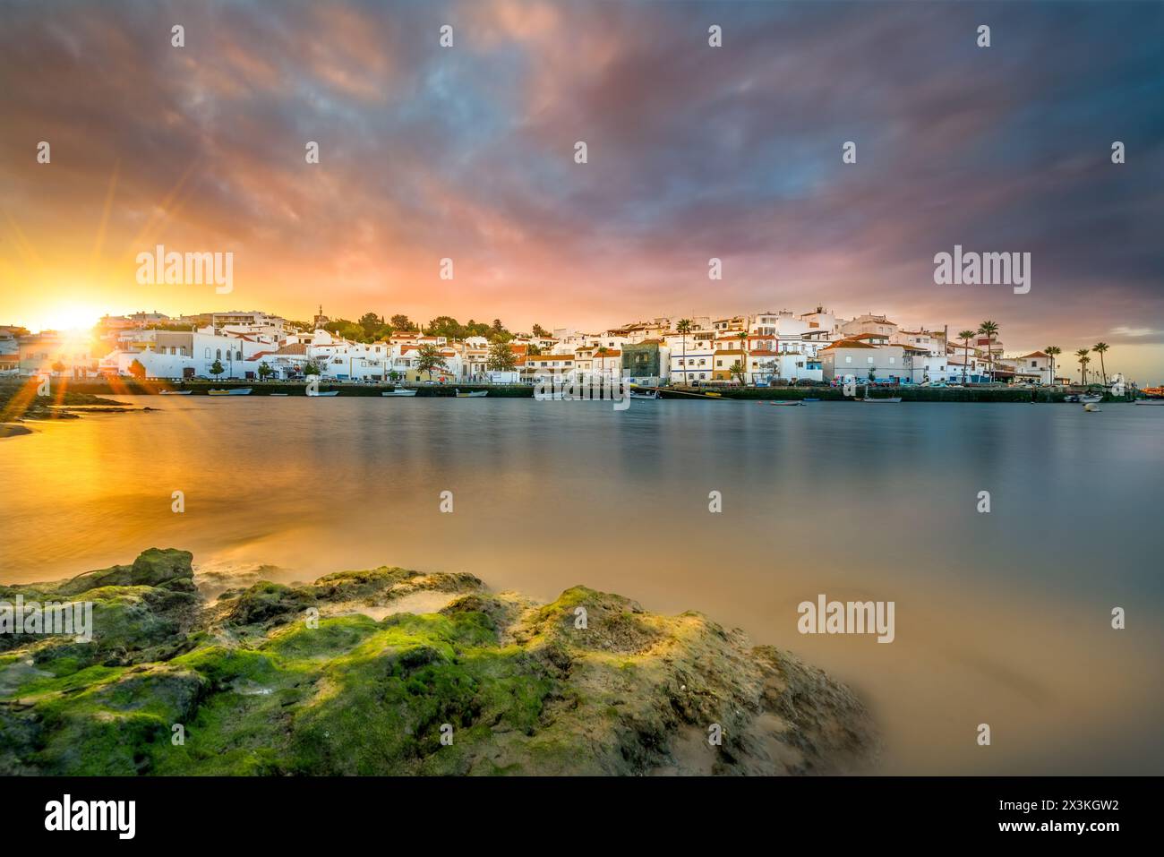 Sonnenaufgang mit Regen über dem Fischerdorf Ferragudo in der Algarve in Portugal Stockfoto