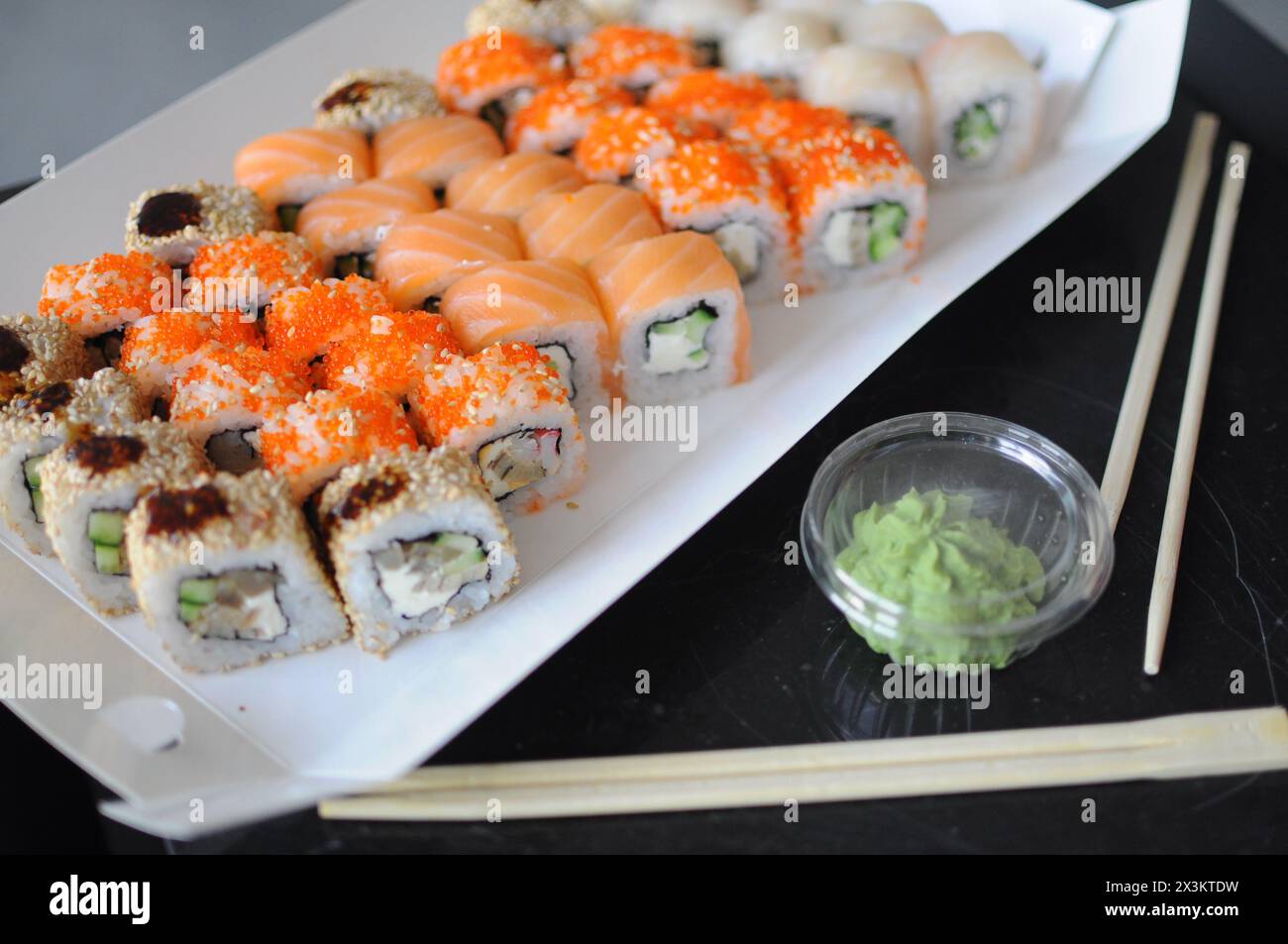 japanisches Sushi. Maki und Brötchen mit Thunfisch, Lachs, Garnelen, Krabben und Avocado. Blick von oben auf verschiedene Sushi. Rainbow Sushi Roll, Uamaki, Hosomaki und Stockfoto