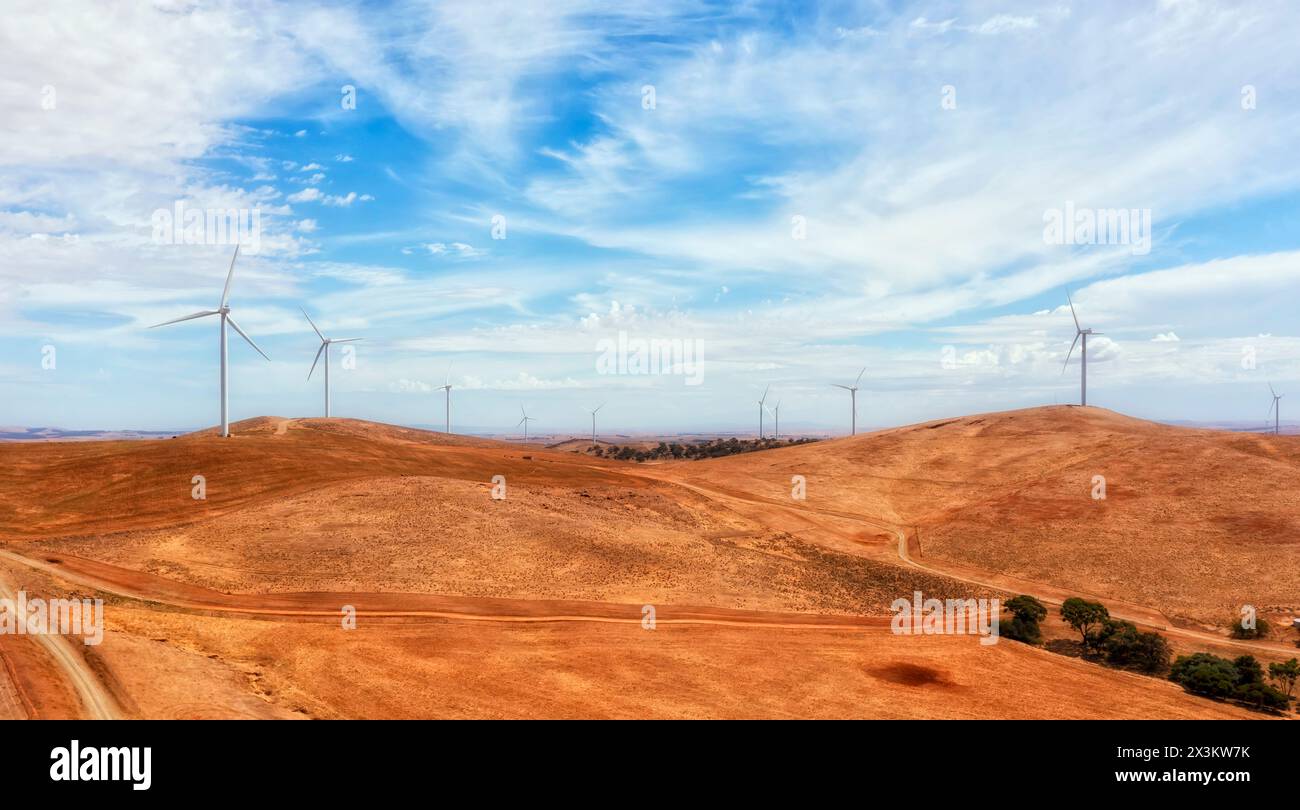 Weite Sicht auf Windmühlenturbinen auf Hügeln im abgelegenen Süden Australiens, die erneuerbare Energie aus Windenergie erzeugen. Stockfoto