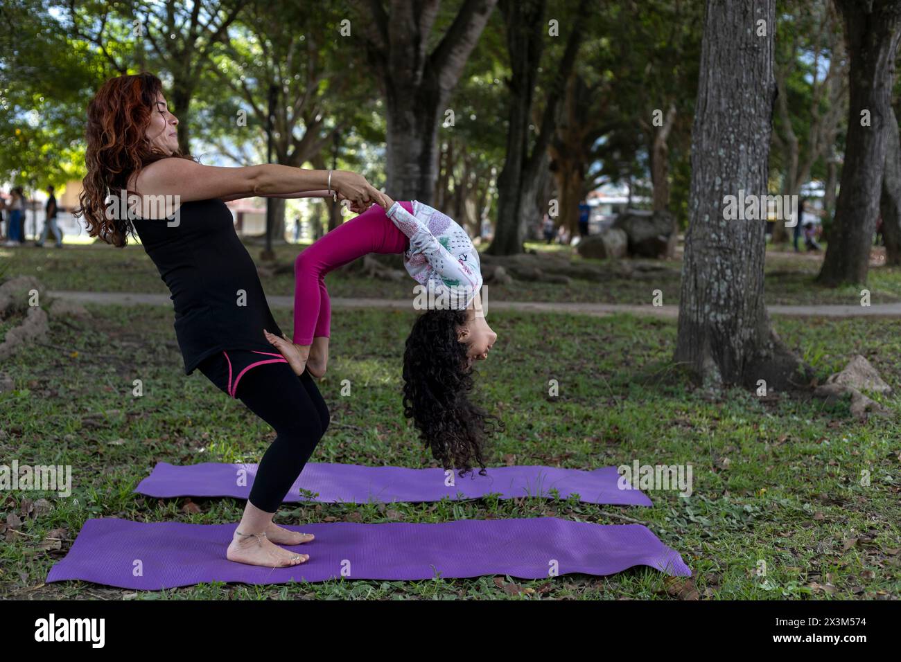 Lateinamerikanische Mutter und Tochter haben Spaß im Park beim gemeinsamen Yoga und Sport Stockfoto