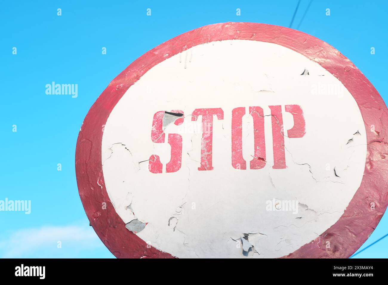 Kreisförmiges rotes Stoppschild, Warnung vor klarem blauem Himmel. Stockfoto