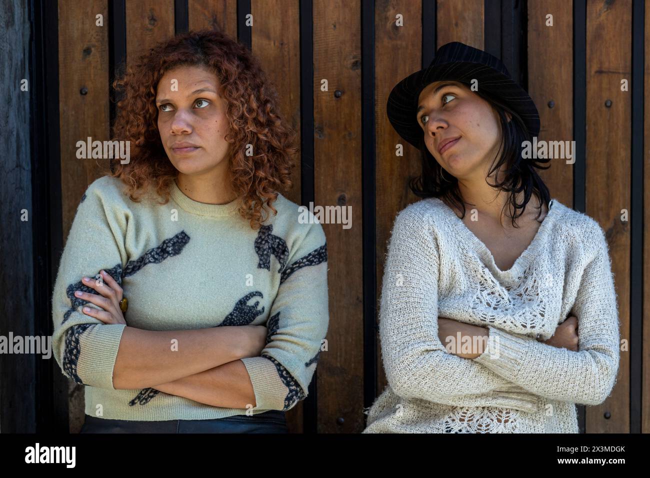 Zwei Erwachsene lateinamerikanische Frauen (34 und 29) mit grünen Augen kämpfen, sie sind nicht gut gelaunt und eine von ihnen ist wütend. Lifestyle-Konzept. Stockfoto