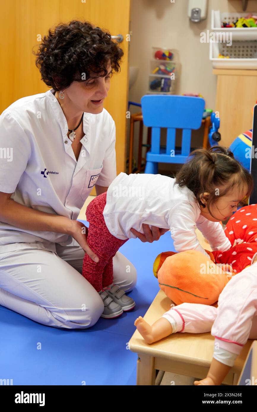 Physiotherapeut Lehre ein Mädchen mit Down-syndrom, oben zu stehen, Rehabilitation, Amara Berri Health Center Gebäude, Donostia, San Sebastian, Gipuzkoa, Stockfoto