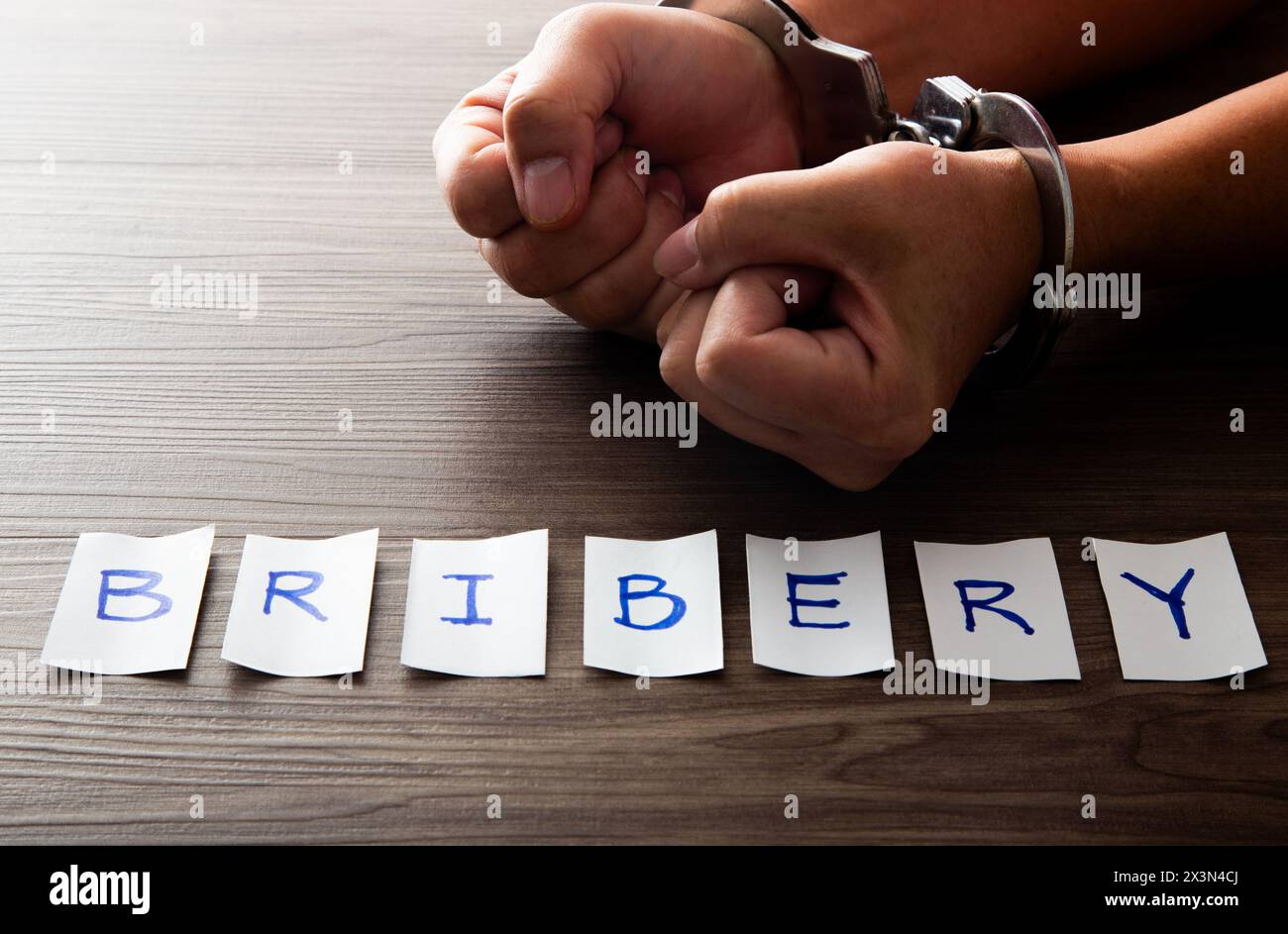 Die Hände eines Geschäftsmannes in Handschellen. Konzept der Bestechung Stockfoto