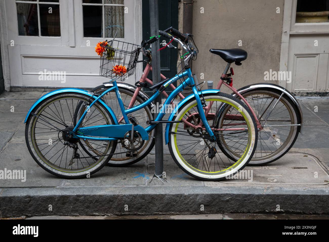 French Quarter, New Orleans, Louisiana.  Zwei Fahrräder zu einem Pfosten auf königliche Straße gesperrt. Stockfoto