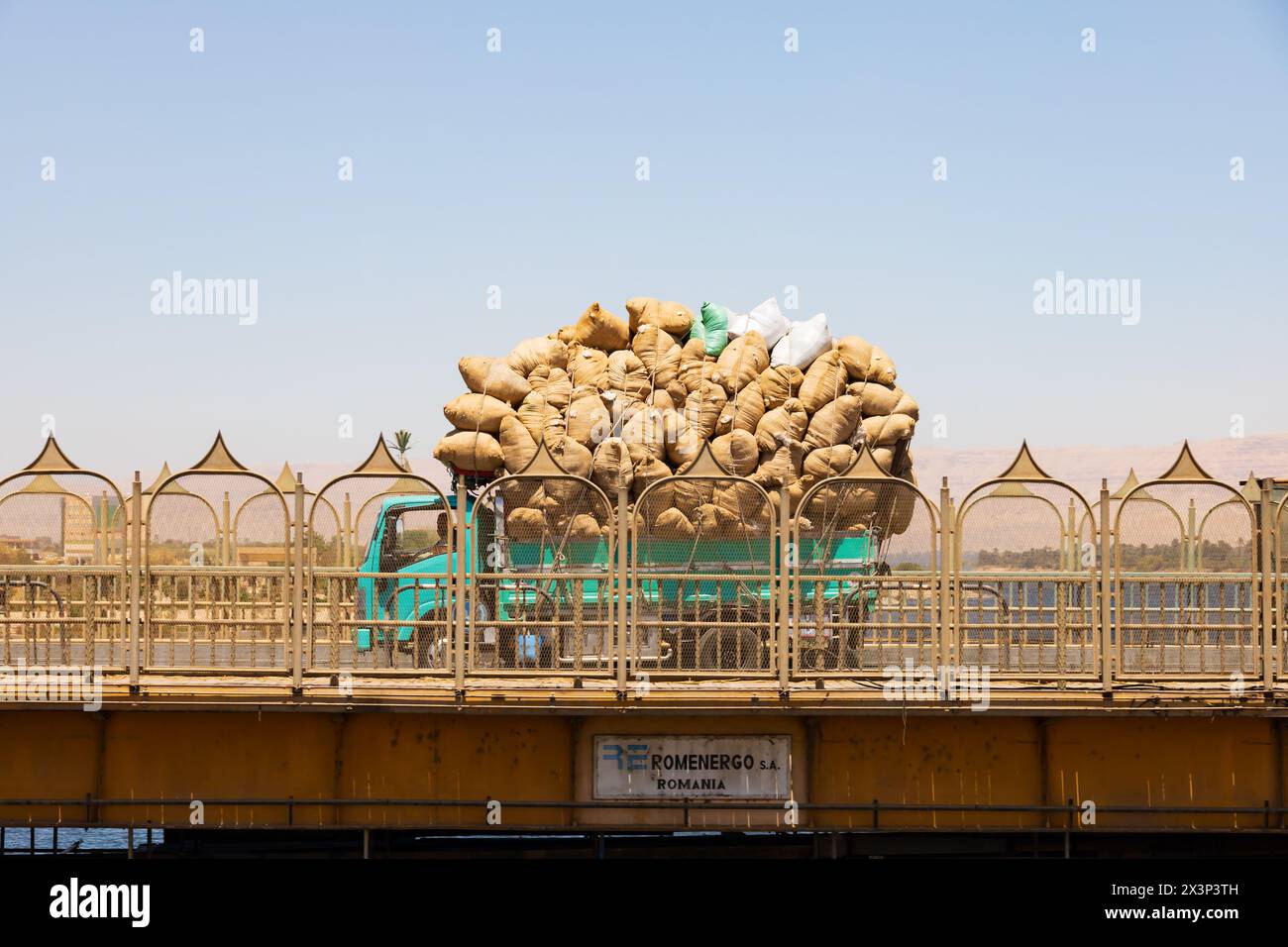 Stark überladener grüner Lkw mit Baumwollsäcken über die neue Brücke, Strombrücke, Schleuse bei Esna am Nil. Ägypten Stockfoto