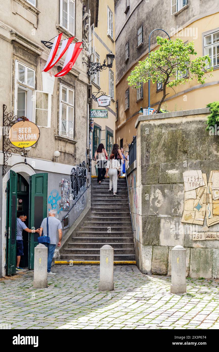 Wien, Österreich. Blick auf die Griechengasse, während einige Touristen die alte Treppe des griechischen Viertels erklimmen. Vertikales Bild. 02.08.2023. Stockfoto