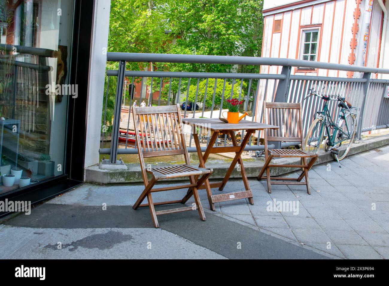 Café auf der freien Luft. Stühle und Tische draußen bei Sommersonnenwetter in Deutschland in der Nähe des Flusses. Design des Möbelsets für das Sommercafé oder Restaurant Stockfoto