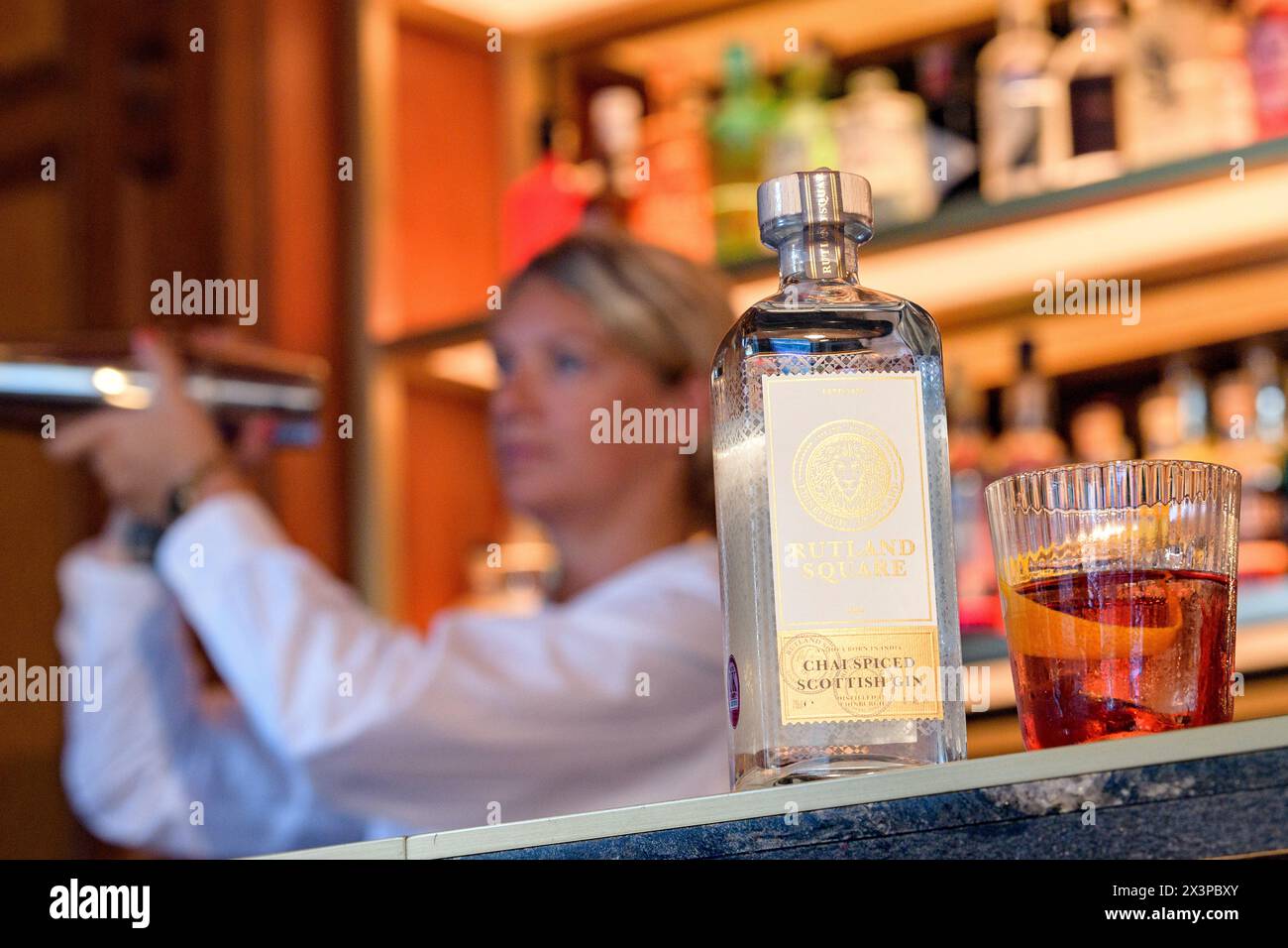 Ein Barkeeper gießt eine Flasche Rutland Square Gin, ein von Virgin StartUp unterstütztes Unternehmen, in einer Bar in Edinburgh, Schottland, UK Stockfoto