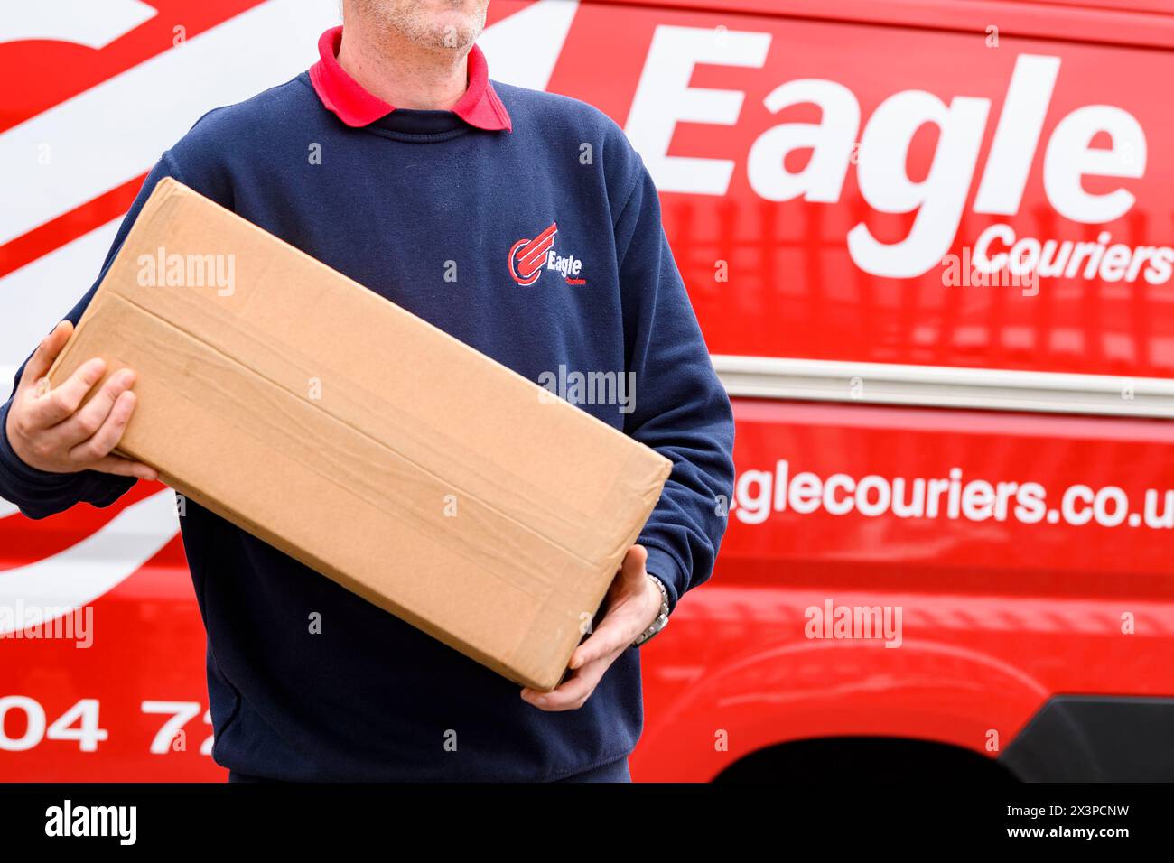 Marken-Van und ein Kurier mit einem Paket bei der schottischen Kurier- und Logistikfirma Eagle Couriers, Schottland, UK Stockfoto