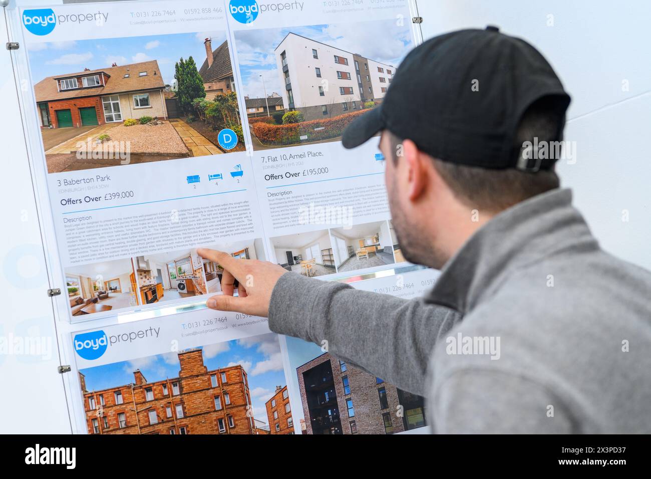 Ein Mann betrachtet Immobilienangebote im Schaufenster von Boyd Legal, Anwälten und Immobilienmaklern, Edinburgh, Schottland, UK Stockfoto