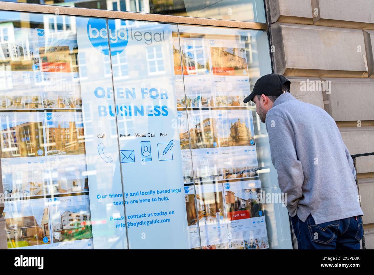 Ein Mann betrachtet Immobilienangebote im Schaufenster von Boyd Legal, Anwälten und Immobilienmaklern, Edinburgh, Schottland, UK Stockfoto