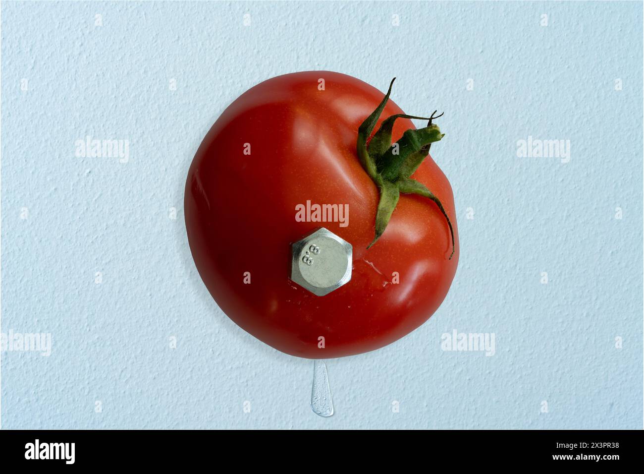 Tomate wurde mit einem riesigen Sechskantschraube an der Wand befestigt. Saft spritzt auf beiden Seiten heraus. Konzeptfotografie. Stockfoto