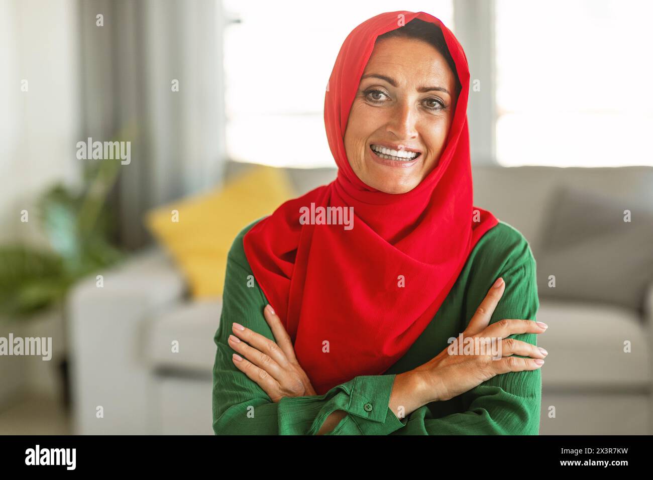 Fröhliche Frau mit rotem und grünem Hijab Stockfoto