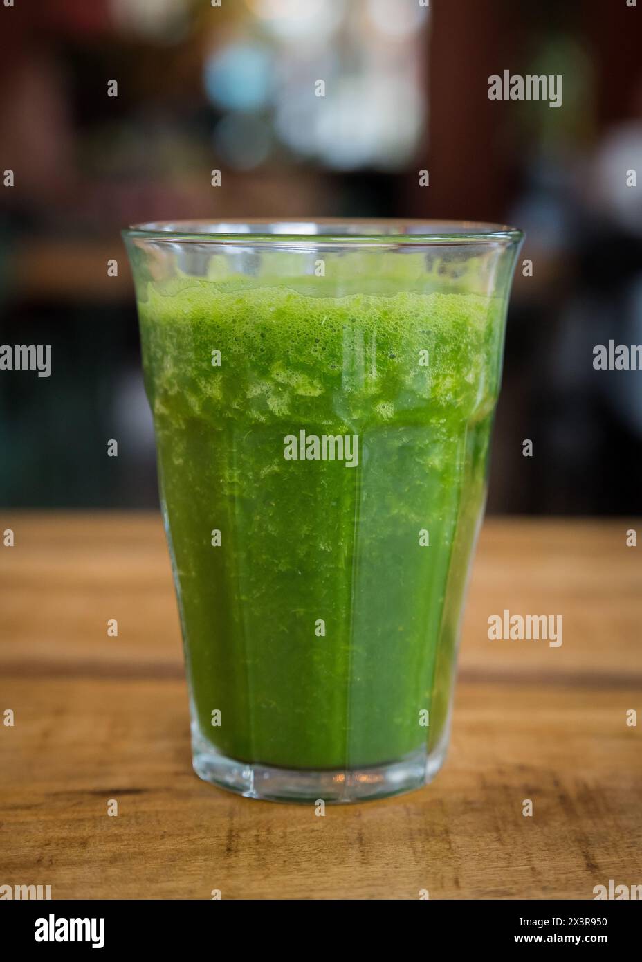 Hausgemachter frischer grüner Smoothie im Glas auf einem Holztisch in einem Café-Restaurant Stockfoto