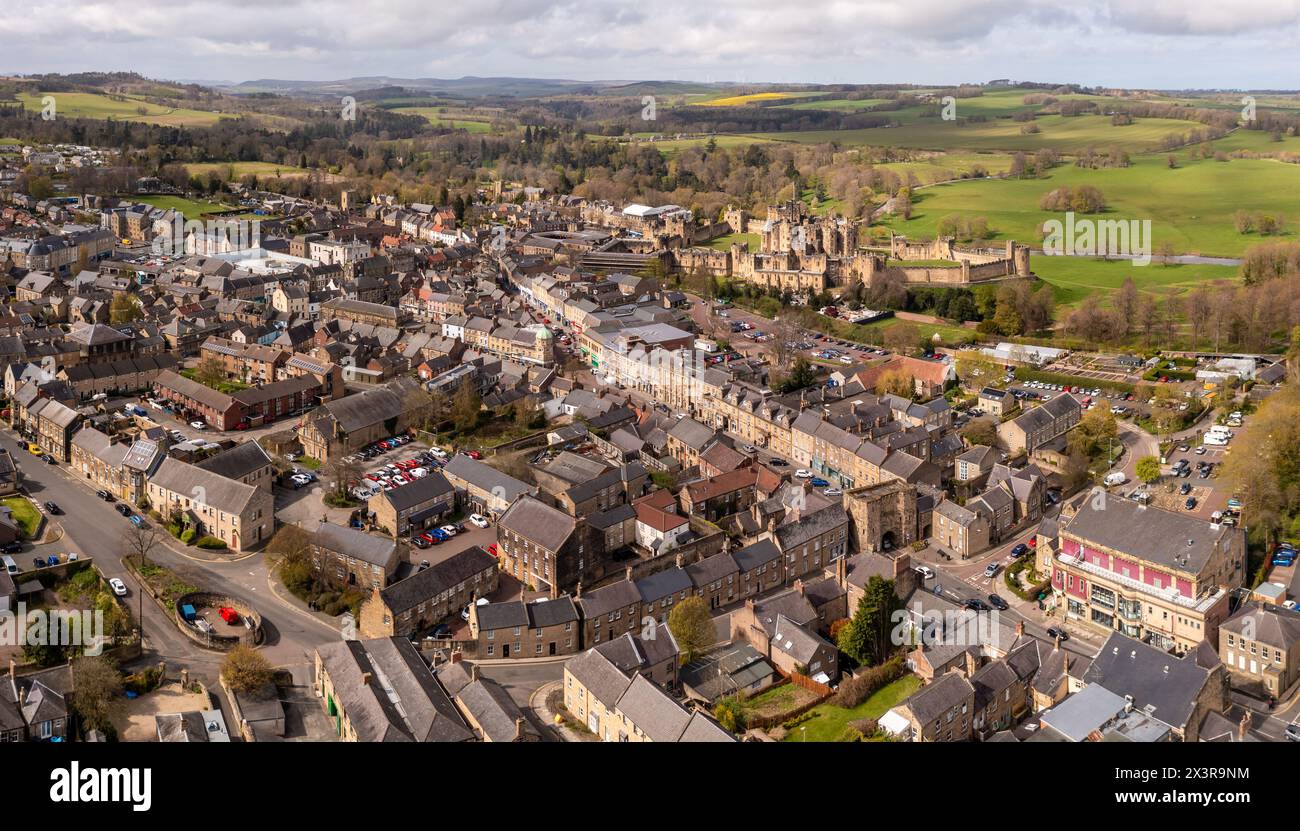 ALNWICK CASTLE, NORTHUMBERLAND, GROSSBRITANNIEN - 19. APRIL 2024. Ein Blick aus der Vogelperspektive auf das alte Alnwick Castle und das Bondgate-Viertel des Stadtzentrums von Alnwick Stockfoto