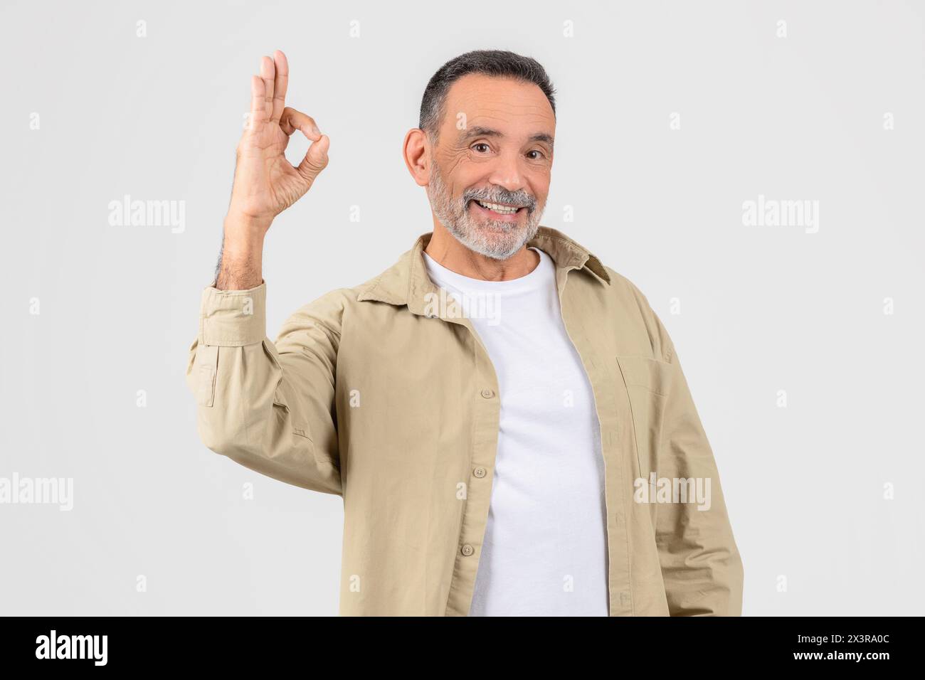 Mann in weißem Hemd und Tan Jacket machen OK-Zeichen Stockfoto