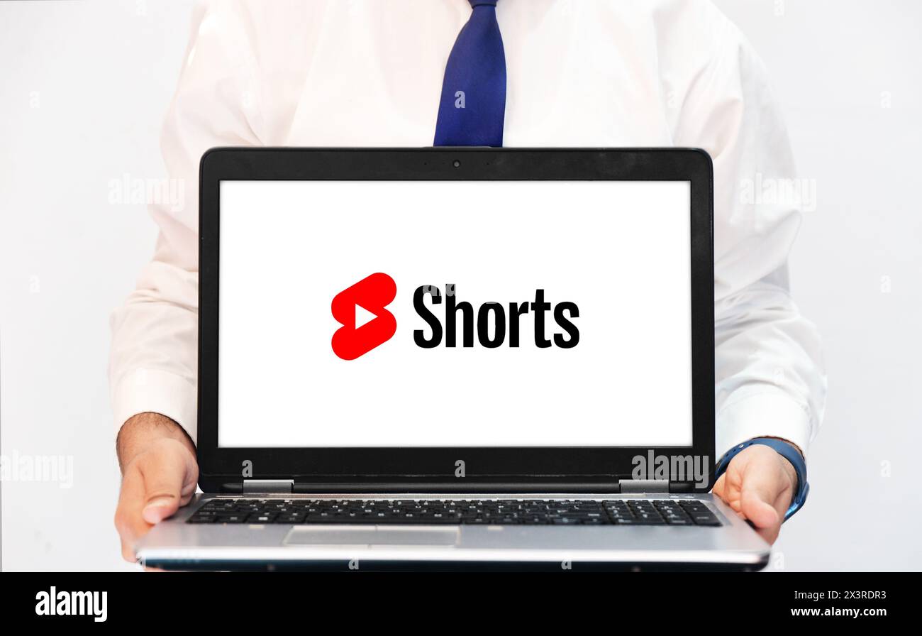 Person mit Webversion von YouTube Shorts auf Laptop, redaktioneller Hintergrund Stockfoto