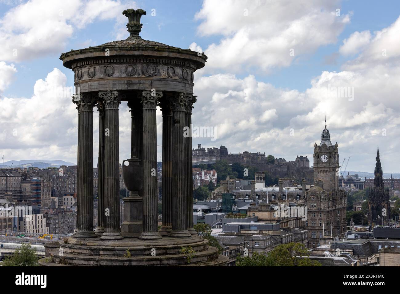 Das Dugald Stewart Monument auf Calton Hill, Edinburgh, mit dem Balmoral Hotel und Edinburgh Castle in der Ferne Stockfoto